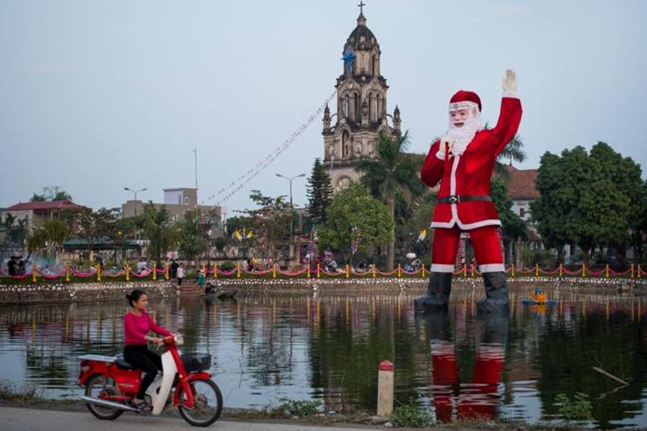 Hanoi, Vietnam, un babbo Natale gigante su lago di fronte alla Phu My Cathedral, Getty